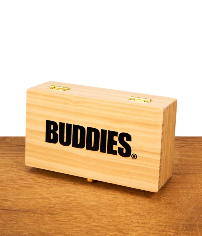 Geschlossene rechteckige Holzbox mit schwarzem „BUDDIES“ Aufdruck und goldfarbenen Scharnieren steht auf einer Holzoberfläche vor weißem Hintergrund.