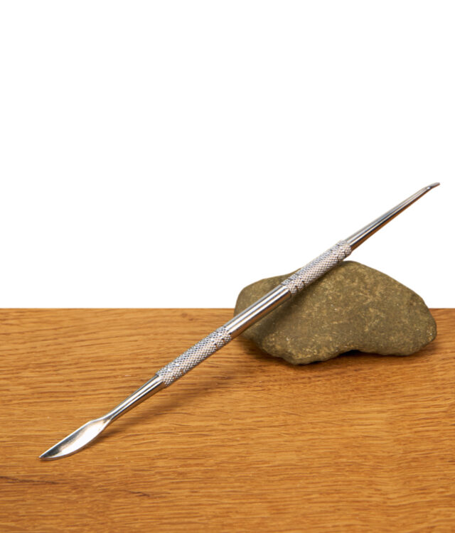 Zweiseitiges Black Leaf Edelstahl Dabbing Tool liegend auf einem Dekostein präsentiert