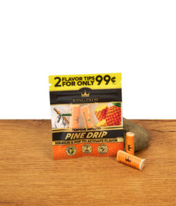 Arrangement aus King Palm Pine Drip Flavor Tips Packung und zwei einzelnen Tips vor einem Dekostein