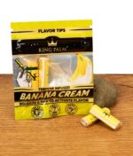 King Palm Banana Cream Verpackung mit zwei gelben Filter Tips und Dekostein präsentiert