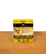 Stehende Verpackung der King Palm Banana Cream Terpene Infused Tips auf einer Holzplatte