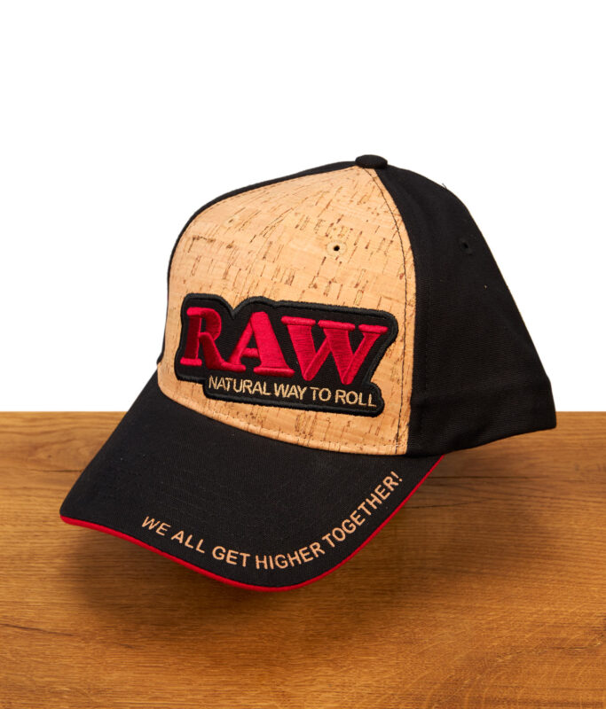 RAW Cork Panel Cap mit Front aus natürlichem Kork, schwarzem Schirm und besticktem RAW-Logo auf einer Holzoberfläche.