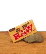 Geschlossene Packung der RAW Classic Double Wide Papers mit authentischem Branding und Hanfkordel-Optik im Lifestyle-Setting.