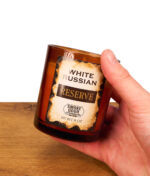 Lifestyle-Aufnahme der 9oz Smoke Odor White Russian Kerze in der Hand gehalten zur Veranschaulichung der kompakteren Reserve-Größe.