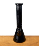 Schwarze Beakerbong von Black Leaf mit auffälligen Mustern, gerade und zentral fotografiert auf Holztisch.