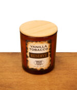 Smoke Odor Reserve Vanilla Tobacco Anti-Tabak-Kerze im braunen Glas mit Holzdeckel auf einer Echtholz-Unterlage.