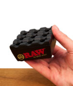 Lifestyle-Nahaufnahme des kompakten RAW Regal Ashtray Black in einer Hand zur Verdeutlichung der ergonomischen Form und Größe.