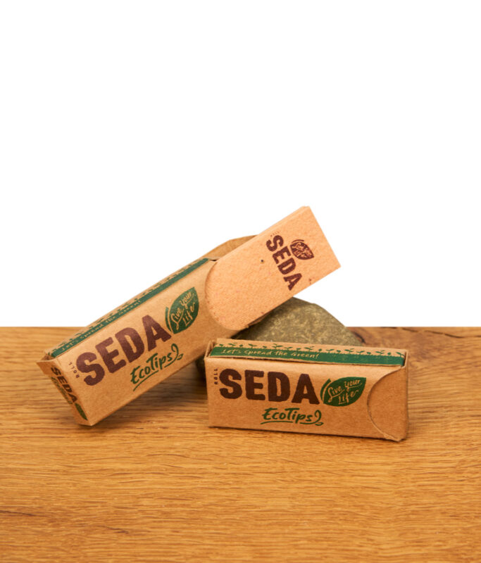 Zwei Heftchen SEDA EcoTips Filtertips auf Holzuntergrund, eine Packung geschlossen und eine geöffnet mit sichtbaren braunen Papierfiltern.