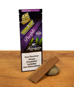 Lila Kingpin Hemp Wraps Purple Verpackung neben einem braunen Hanf-Wrap, der dekorativ auf einem Stein präsentiert wird.