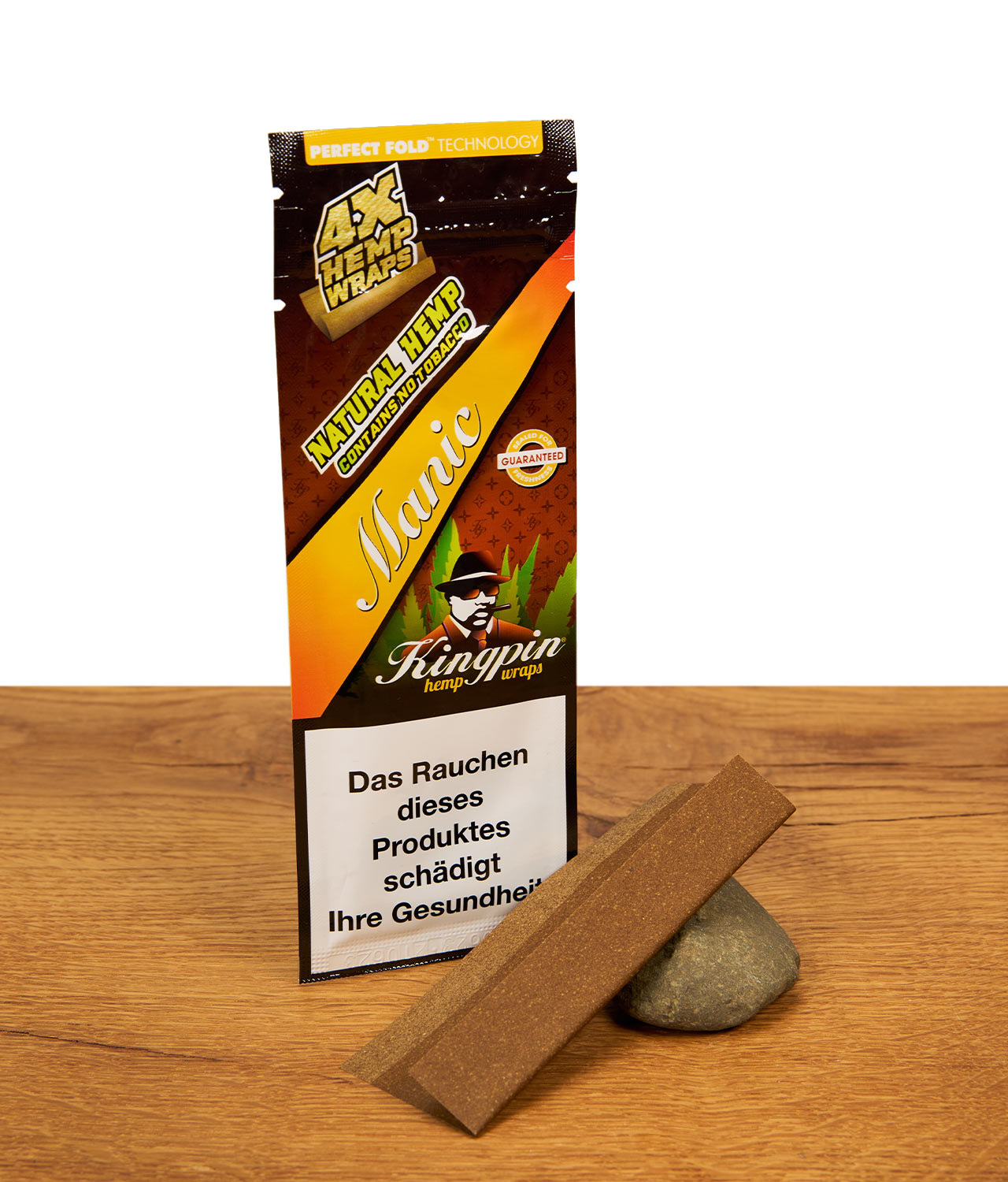 kingpin-hemp-wraps-manic-jpg Packung Kingpin Hemp Wraps Manic neben einem einzelnen, vorgefalteten Blunt-Leaf, das auf einem kleinen Stein auf Holz präsentiert wird.