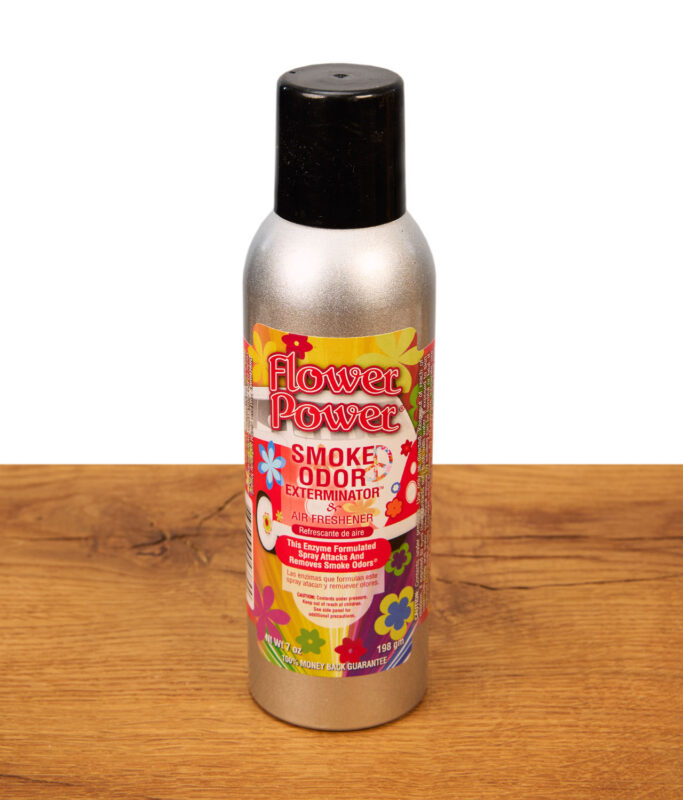 Smoke Odor Exterminator Lufterfrischer Spray in der Duftrichtung Flower Power in einer silbernen 7oz Metalldose auf Holzgrund.