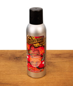 Smoke Odor Exterminator Spray Cherry Bomb mit enzymatischer Formel gegen Rauchgerüche in einer silbernen Dose auf einer Holzoberfläche.