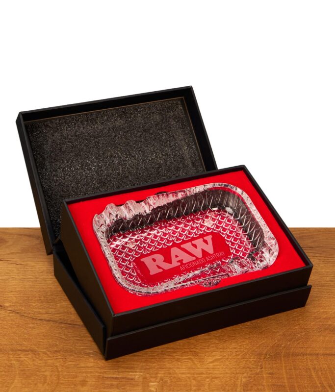 Geöffnete Präsentationsbox des RAW Aficionado Glass Ashtray mit hochwertiger, roter Polsterung für sichere Aufbewahrung.