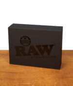 Edle schwarze Geschenkverpackung des RAW Aficionado Glass Ashtray mit dezentem Logo-Aufdruck auf einem Holztisch.