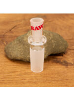 Detailansicht des RAW ConeVerter 14mm Schliff-Adapters aus klarem Glas mit rotem RAW-Logo vor einem Naturstein.