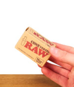 Eine Hand hält die kompakte Kartonverpackung des RAW ConeVerter 14mm Size Adapters für Joints und Cones.