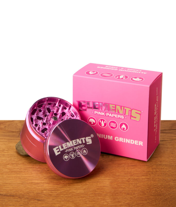 Elements Pink Grinder 4-teilig aus Aluminium neben der rosa Verpackungsbox. Geöffnetes Oberteil mit Magnetverschluss.
