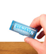 Transparente Elements Rolls 1 1/4 Size Nachfüllbox aus blauem Kunststoff. Der Papierspender wird in der Hand gehalten.
