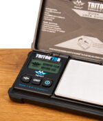 Bedienfeld der Triton T3R Taschenwaage von MyWeigh mit LCD-Display, Tara- und Einheiten-Tasten auf einem Holztisch.