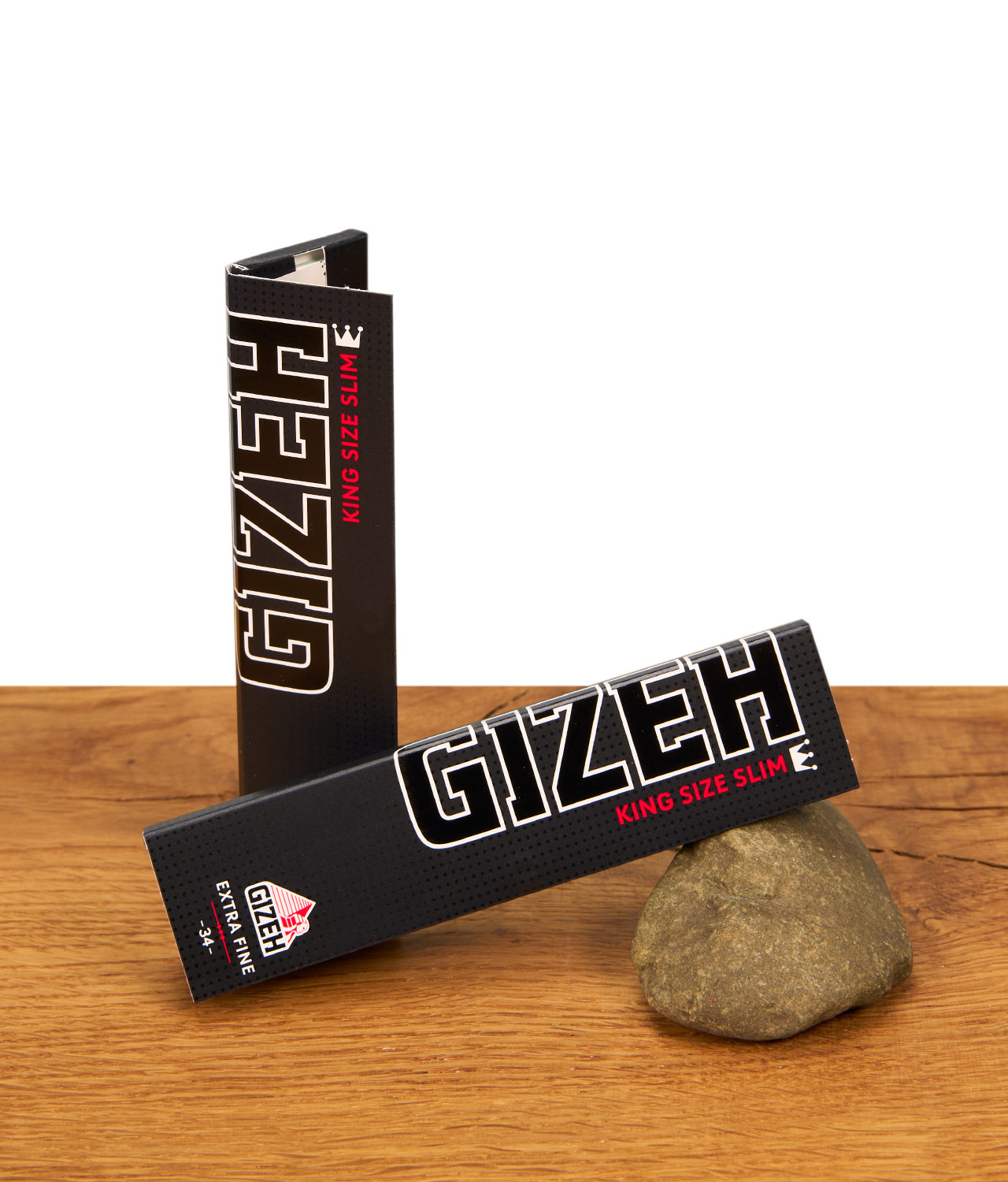 gizeh-black-king-size-paper-jpg Zwei Packungen Gizeh Black King Size Slim Papers mit Magnetverschluss auf einer Holzoberfläche mit Naturstein-Deko.