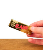 Eine Packung der phänomenal dünnen RAW Ethereal Papers im 1 1/4 Format, präsentiert in einer Hand vor weißem Hintergrund.
