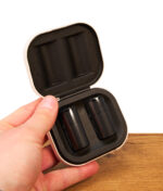 In der Hand gehaltene geöffnete weiße Puffco Pivot Aufbewahrungsbox mit dunkler Einlage, die beide glänzenden schwarzen 3D Chambers zeigt.