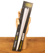 The Original Cones Giga Cone in Originalverpackung mit Sichtfenster, gehalten von einer Gliederhand aus Holz auf einem Tisch.
