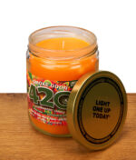 Offene Smoke Odor 420 Exterminator Candle auf Holz, Docht sichtbar, daneben goldener Deckel mit Aufdruck 'Light one up today'.