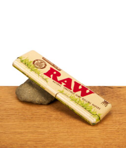 Geschlossenes RAW Organic Hemp Metal Case King Size aus Metall mit Hanf-Print auf einem Holzuntergrund.