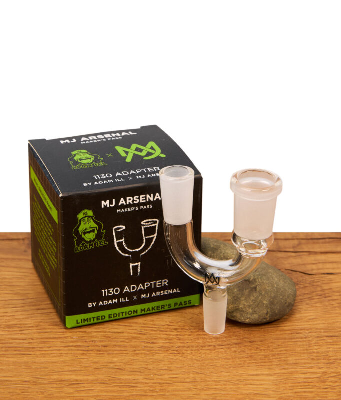 MJ Arsenal 1130 Adapter neben der schwarzen Originalverpackung der "Limited Edition Maker's Pass" Kollaboration mit Adam Ill auf Holzgrund.