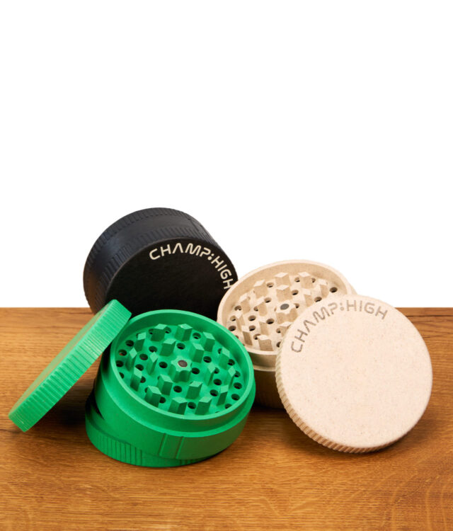 Champ High Maxi Grinder aus Hanf in Schwarz, Grün und Beige mit Magnetverschluss auf einer Holzoberfläche.