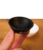 Demonstration der Flexibilität: Die schwarze buyhigh Hash Bowl wird umgedreht gehalten, um das elastische Material zu zeigen.