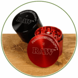 Ein schwarzer und roter Grinder von RAW auf Holz. Gilt als Kategorie-Icon für Grinder von RAW auf buyhigh dem Headshop