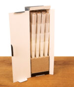 Geöffnete Kartonverpackung zeigt das 64er Pack Cones Black King Size Prerolled mit Filtertip auf Holztisch.
