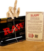 RAW Black Rolling Tray mit "Certificate of RAWthenticity" und einer hölzernen Handfigur, die darauf zeigt.