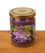 Geschlossene Smoke Odor Duftkerze Groov'n Grape in der Limited Edition mit einem farbenfrohen Weintrauben-Etikett und goldenem Schraubdeckel auf einer Holzoberfläche.