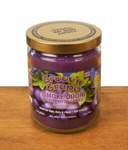 Geschlossene Smoke Odor Duftkerze Groov'n Grape in der Limited Edition mit einem farbenfrohen Weintrauben-Etikett und goldenem Schraubdeckel auf einer Holzoberfläche.