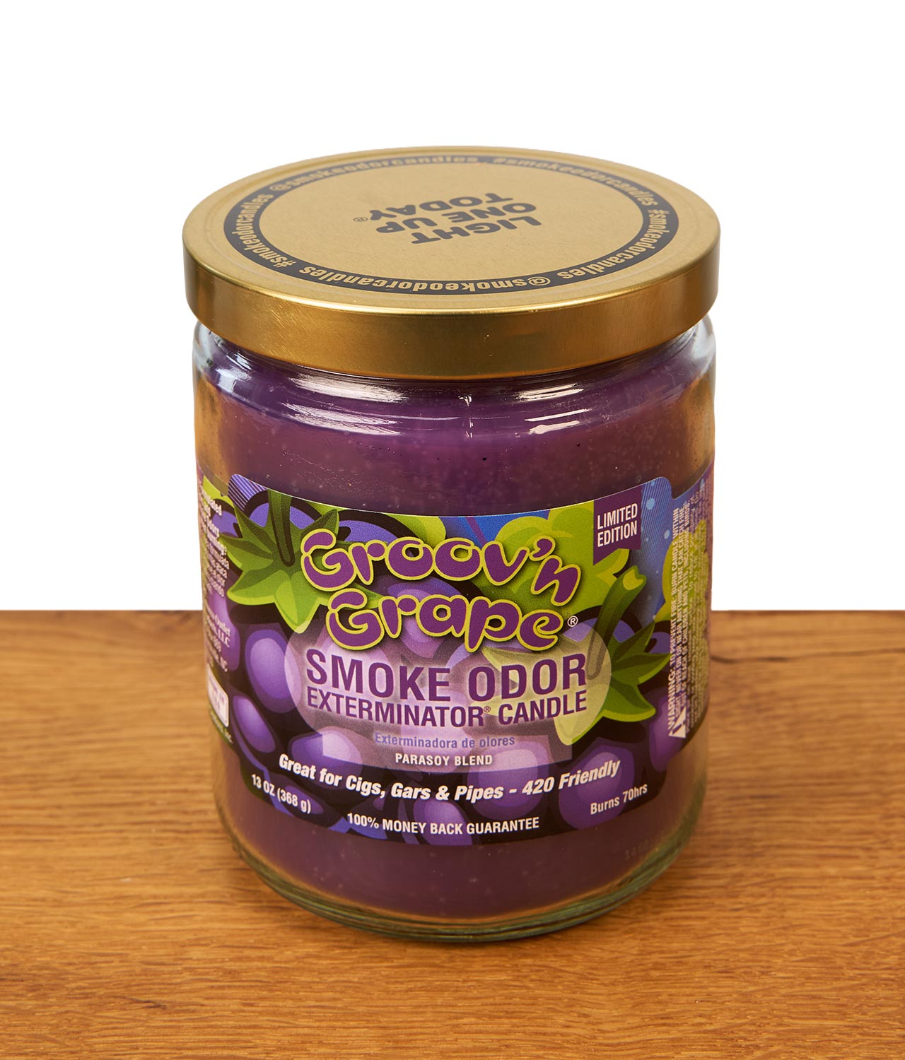 smoke-odor-duftkerze-groovin-grape-jpg Geschlossene Smoke Odor Duftkerze Groov'n Grape in der Limited Edition mit einem farbenfrohen Weintrauben-Etikett und goldenem Schraubdeckel auf einer Holzoberfläche.