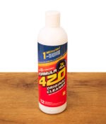 Eine Flasche des originalen Formula 420 Reinigers (12 oz / 354 ml) steht aufrecht auf einer Holzoberfläche; der ideale Express-Reiniger für Glas, Metall und Keramik.