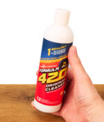 Eine Hand hält die Flasche des Formula 420 Reinigers (Original Cleaner), auf der das Versprechen einer blitzschnellen 1-Minuten-Säuberung ohne Schrubben zu sehen ist.