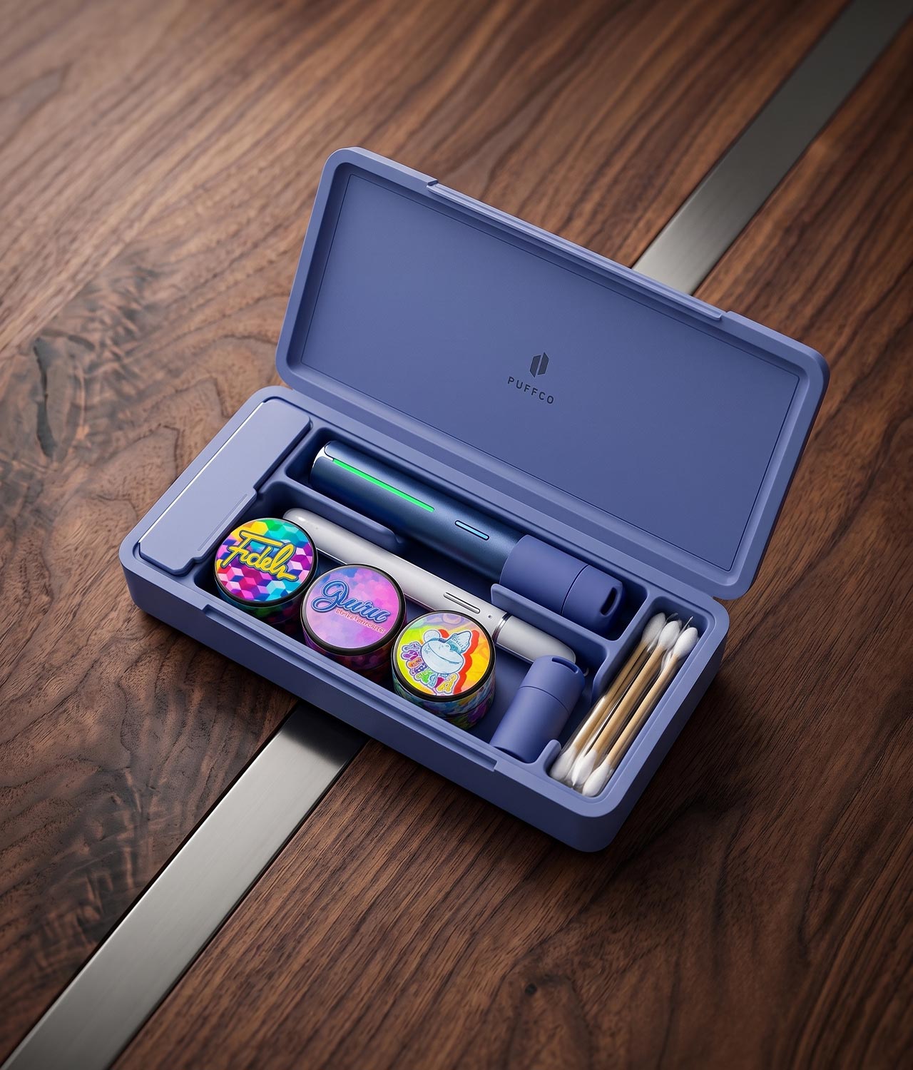 Puffco-sapphire-bundle-with-pivot-and-travel-case-jpg Saphirblaues Puffco Travel Case mit Pivot Vaporizer und Hot Knife zusammen als Bundle auf edlem Wallnuss Holz präsentiert.