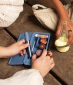 Das Puffco Sapphire Bundle Set auf Holz mit viel Zubehör und dem gelben Peak präsentiert als Lifestyle Foto.