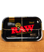 Schwarze RAW Black Classic Rolling Tray Drehunterlage aus Metall mit rotem Logo, mit einer Paketschnur kreuzweise verschnürt.