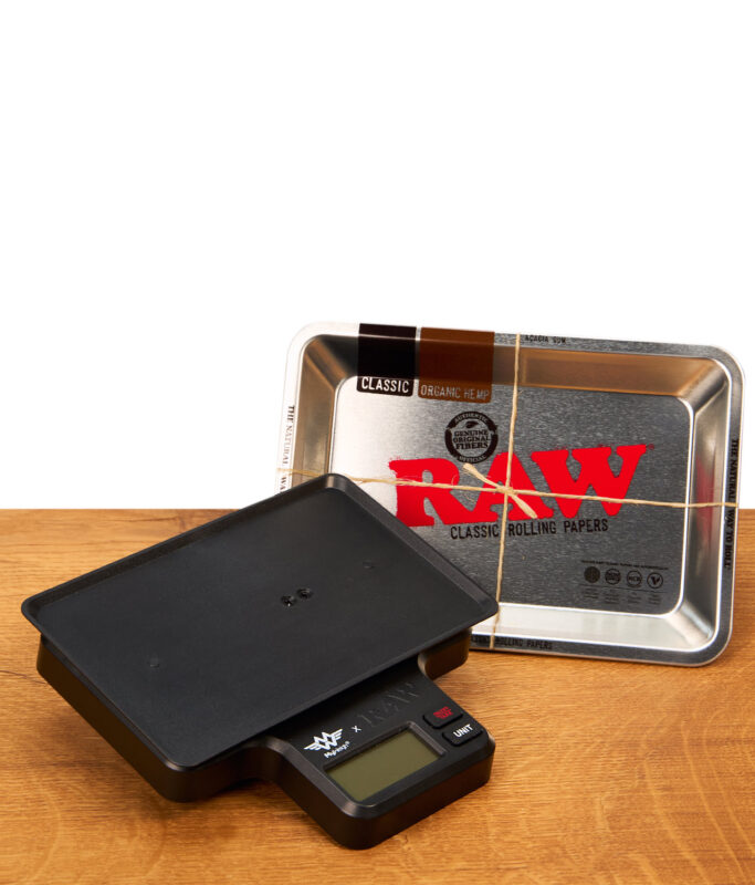 Schwarze digitale RAW Tray Scale Waage neben dem passenden RAW Metall-Tray auf einem Holztisch.