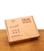 Geschlossene Kartonverpackung der digitalen RAW Tray Scale Waage von MyWeigh mit Aufdruck auf einem Holztisch.