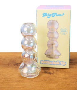 Schillerndes Big Fun Peak Top Bubble Iridescent aus Borosilikatglas. Der Aufsatz steht neben seiner bunten Originalverpackung auf Holz.