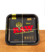 Quadratisches RAW Square Rolling Tray Classic aus Metall im typischen Papier-Design. Die Drehunterlage liegt auf einem Holztisch.