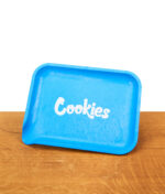 Santa Cruz x Cookies Rolling Tray aus blauem Hanf-Biokunststoff mit weißem Logo auf einer Holzoberfläche.