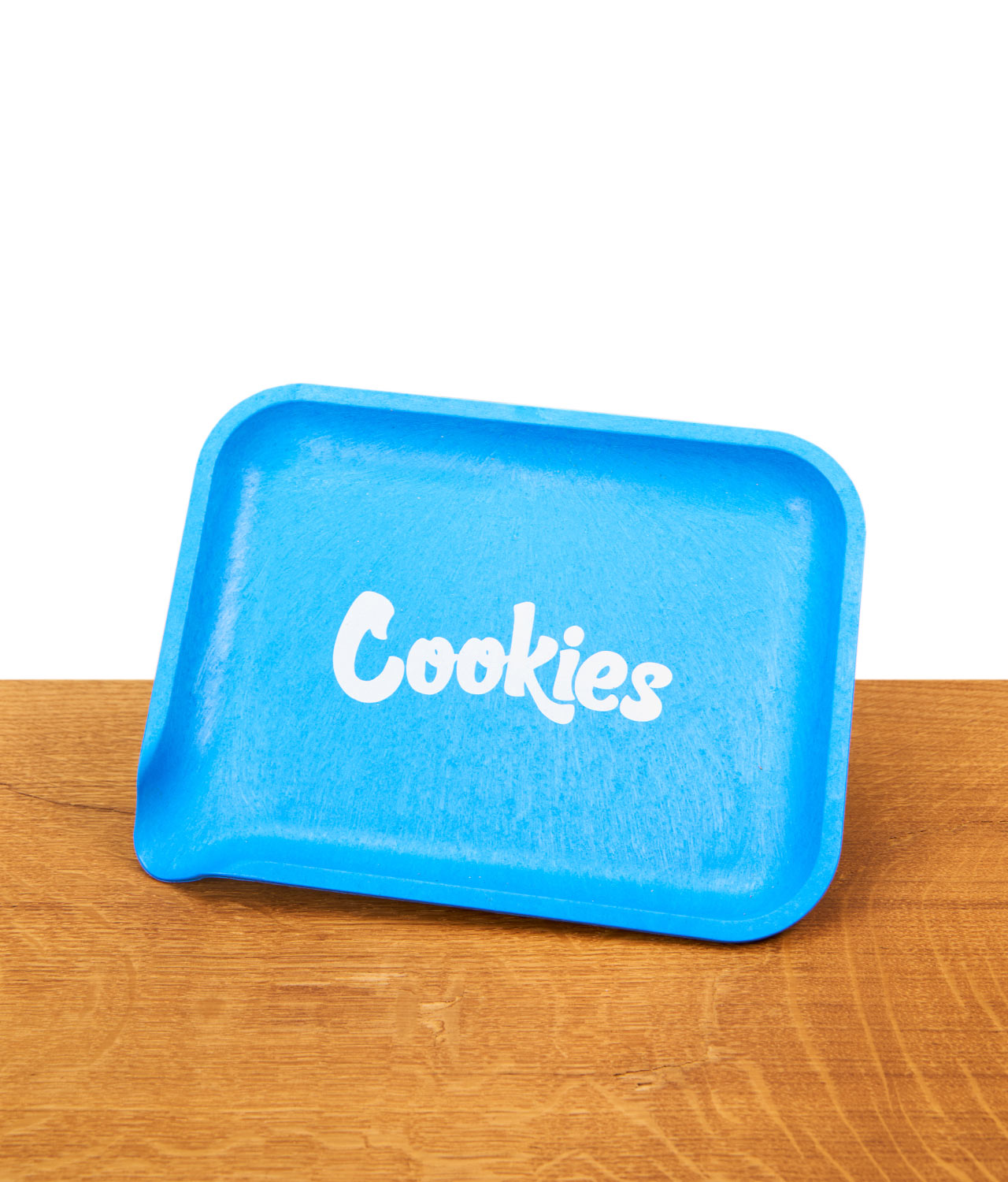 santa-cruz-x-cookies-rolling-tray-hemp-blau-jpg Santa Cruz x Cookies Rolling Tray aus blauem Hanf-Biokunststoff mit weißem Logo auf einer Holzoberfläche.