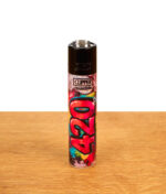 Nachfüllbares Clipper FFX 420 Wallz Feuerzeug mit pinkem „Dope“-Graffiti-Aufdruck auf einer Holzoberfläche.